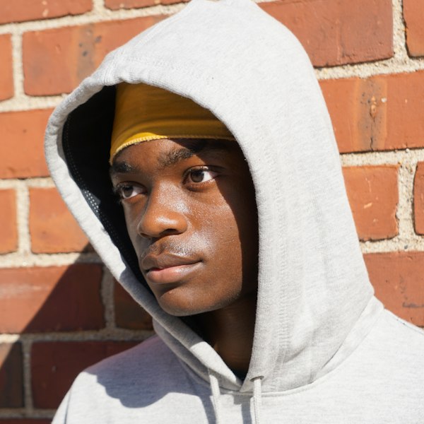 A man wearing a light gray pullover hoodie